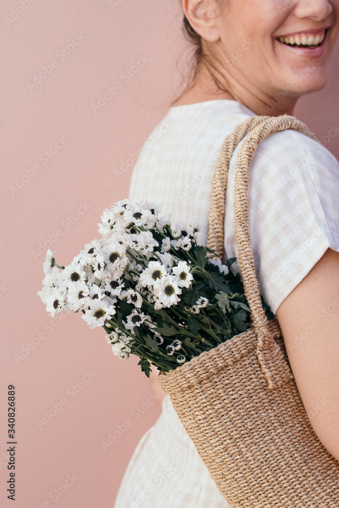 女人提着一袋花