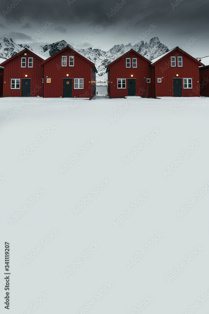 挪威萨克里索伊岛白雪皑皑的海岸上的一排红色小屋
