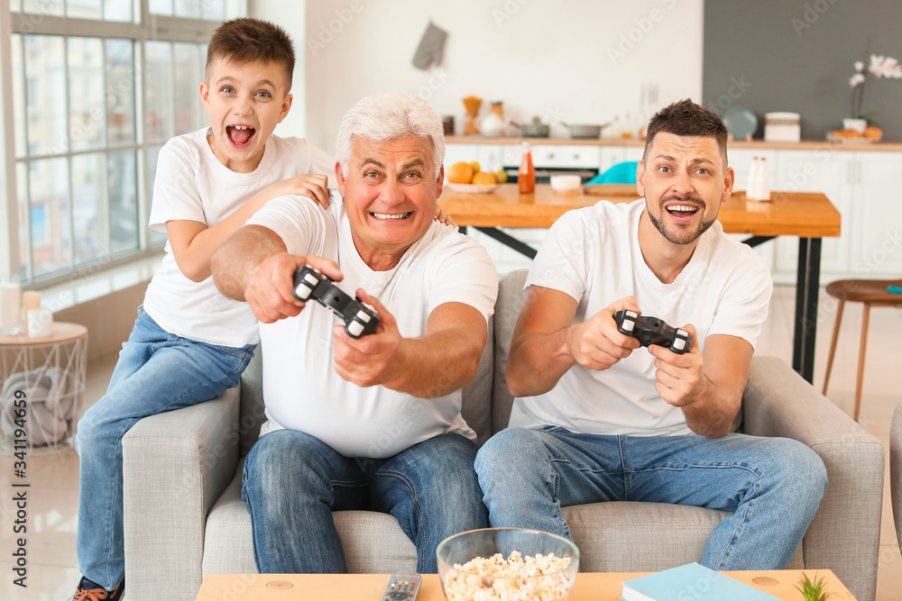 一个男人和他的父亲和儿子在家玩电子游戏