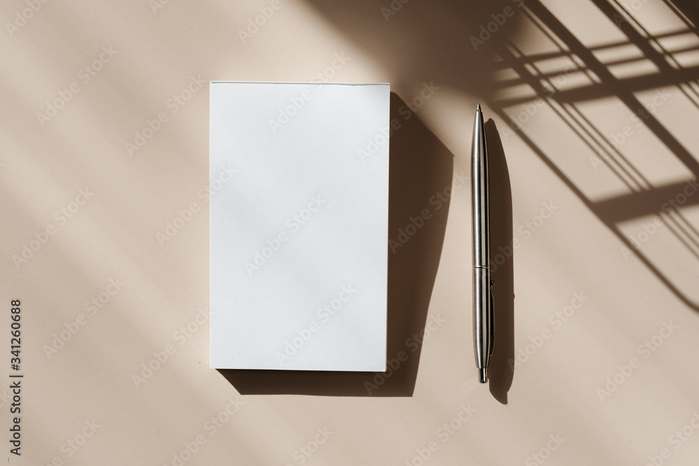 米色背景的空白笔记本和钢笔