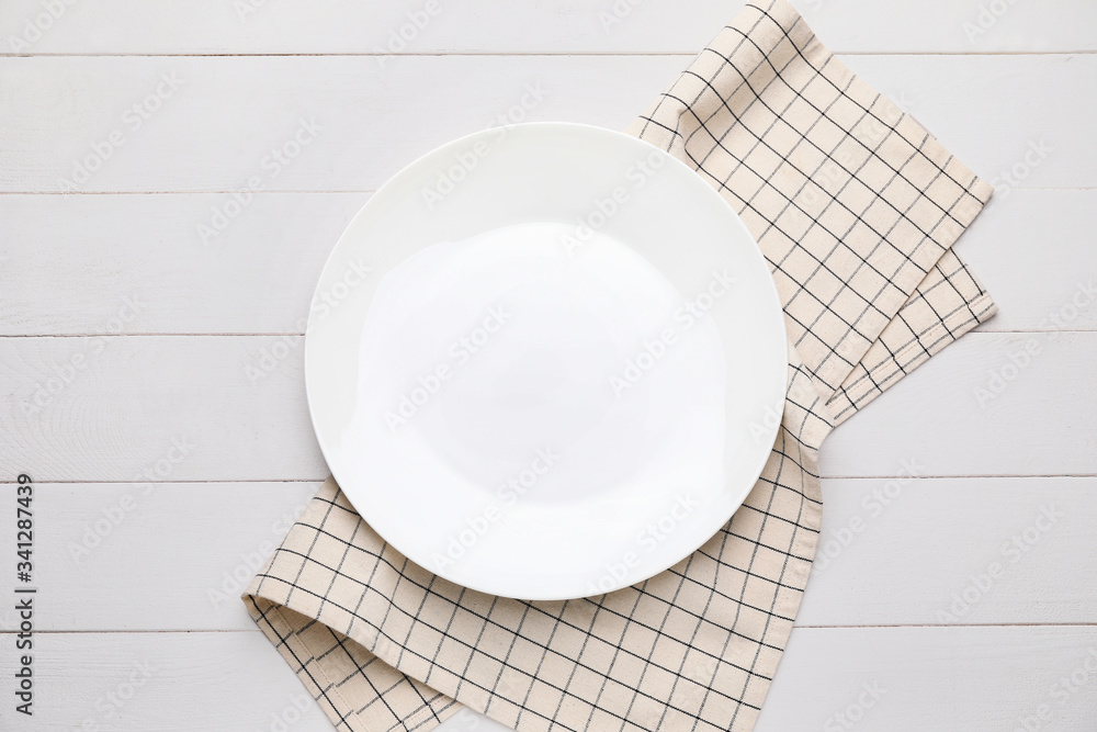 Clean napkin with plate on wooden background