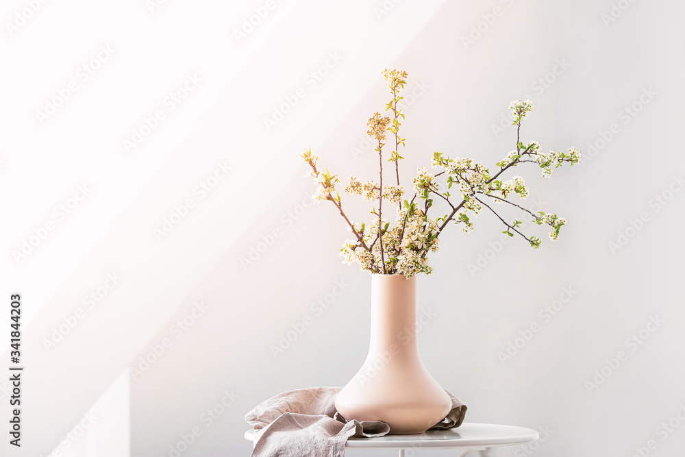 房间桌子上摆着漂亮的开花树枝的花瓶