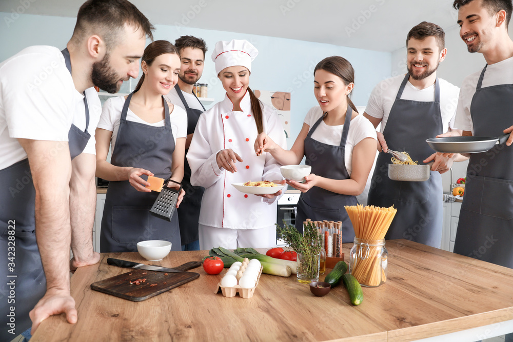 Female chef and group of young people during cooking classes