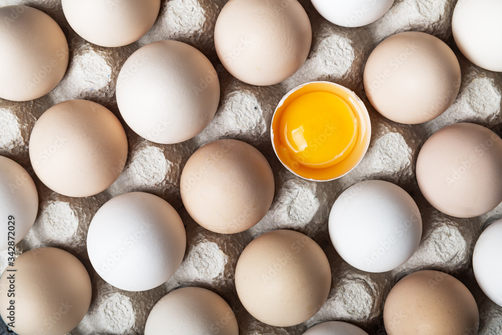 有机包装的鸡蛋特写。鸡蛋在其他鸡蛋中被打碎了一半。食品摄影