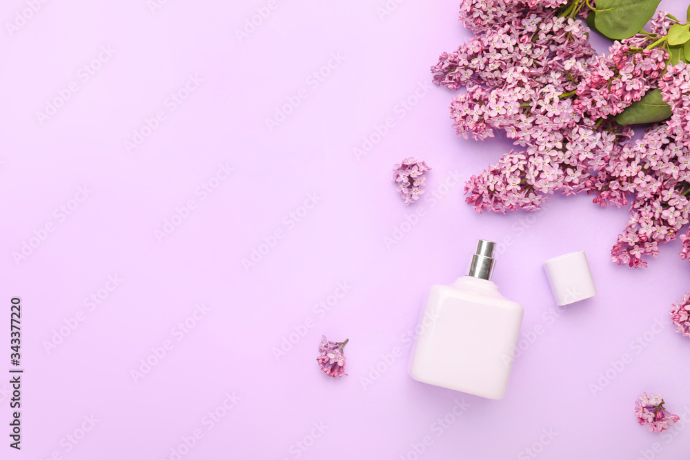 Beautiful lilac flowers and perfume on color background