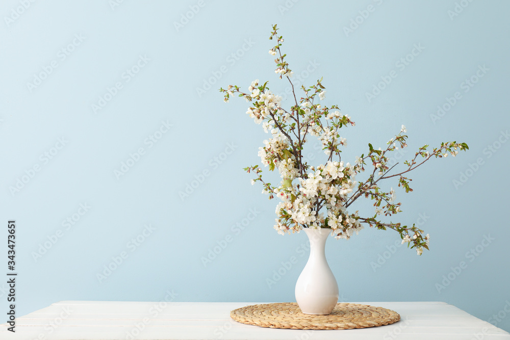 桌上摆放着美丽盛开的树枝的花瓶