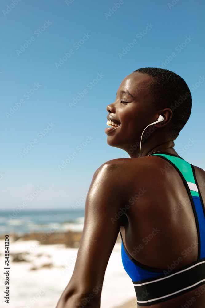 Fitness woman relaxing and listening to music outdoors