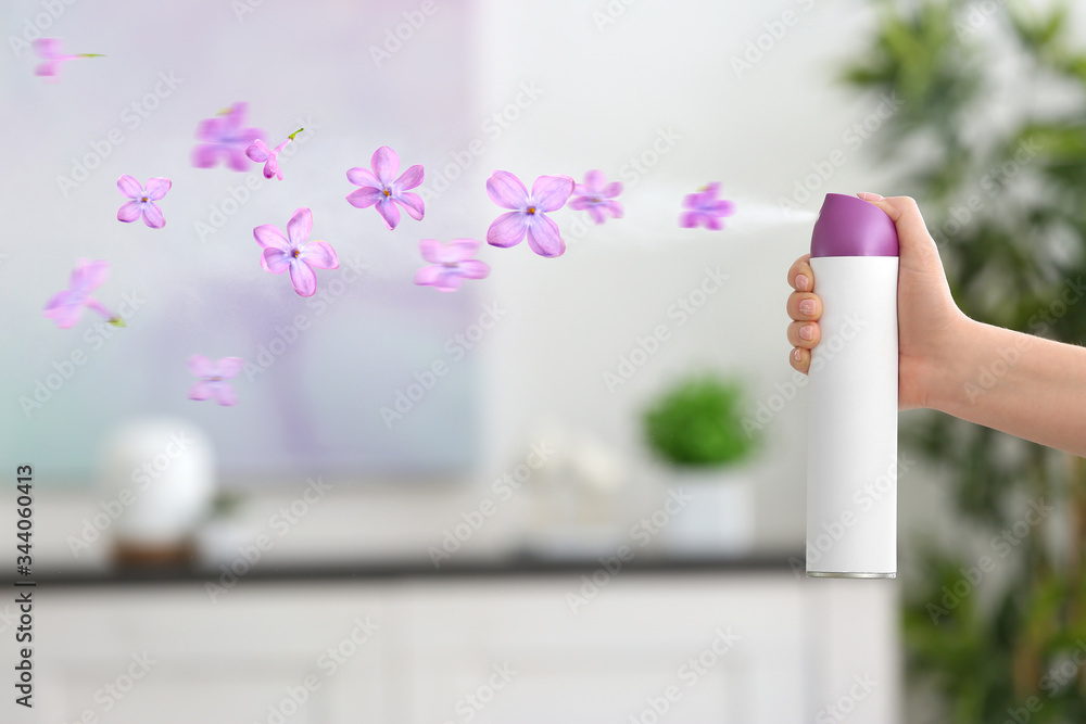 女士在家喷洒花香空气清新剂