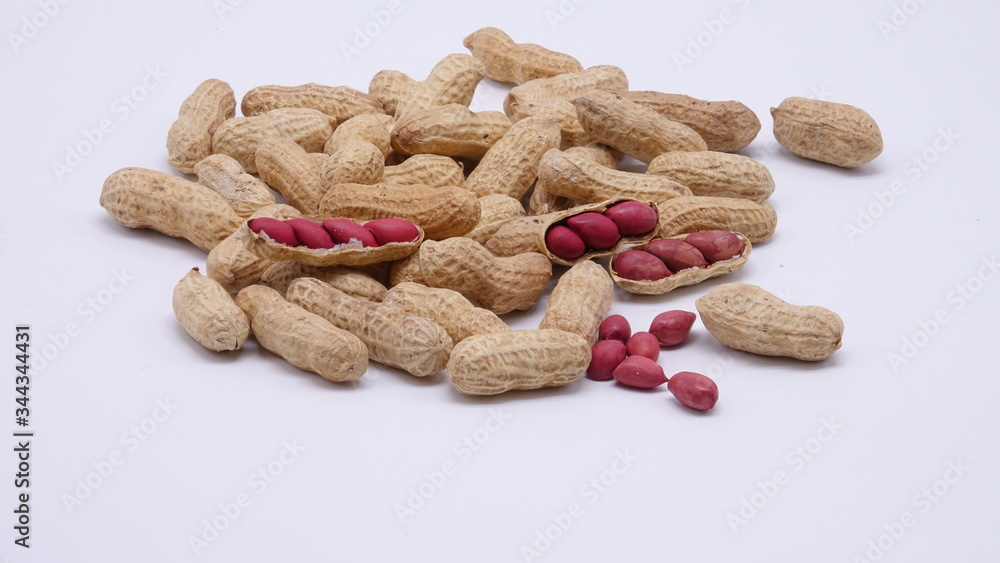Peanuts with brown shells isolated on white background. Red kernels