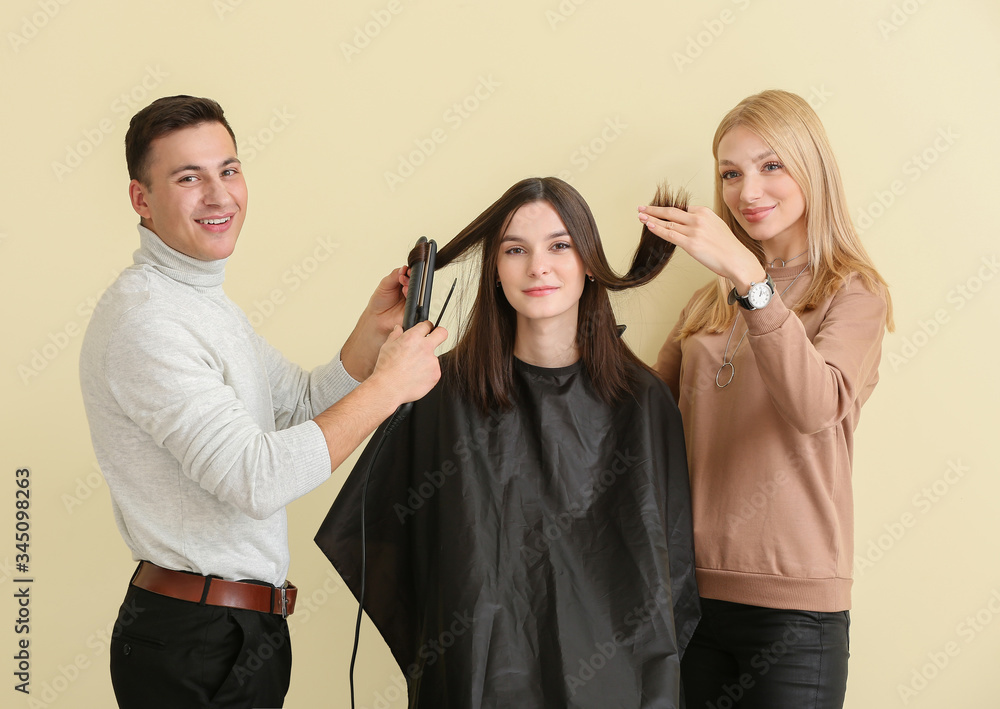 年轻理发师在彩色背景下与客户合作