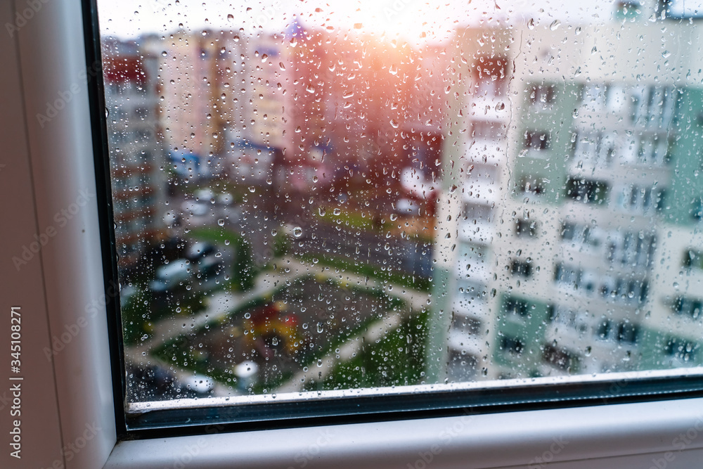 玻璃上的自然水滴。选择性聚焦。雨天城市背景
