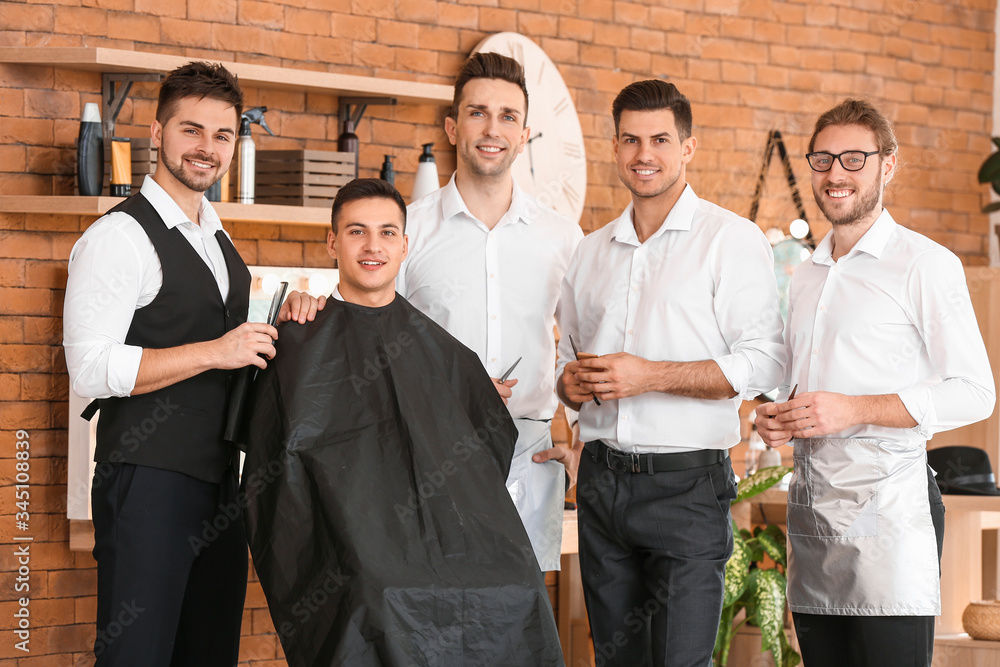 专业理发师在沙龙教年轻男性