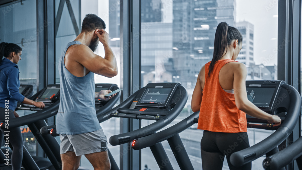 运动人群在跑步机上跑步，进行健身运动。运动和肌肉女性和男性A