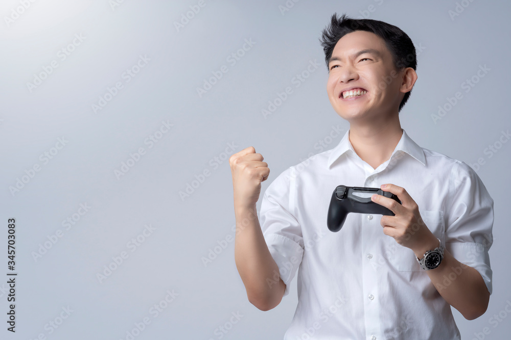 一位年轻迷人的亚洲男子与成功受害者在欢乐棒上玩电子游戏的肖像