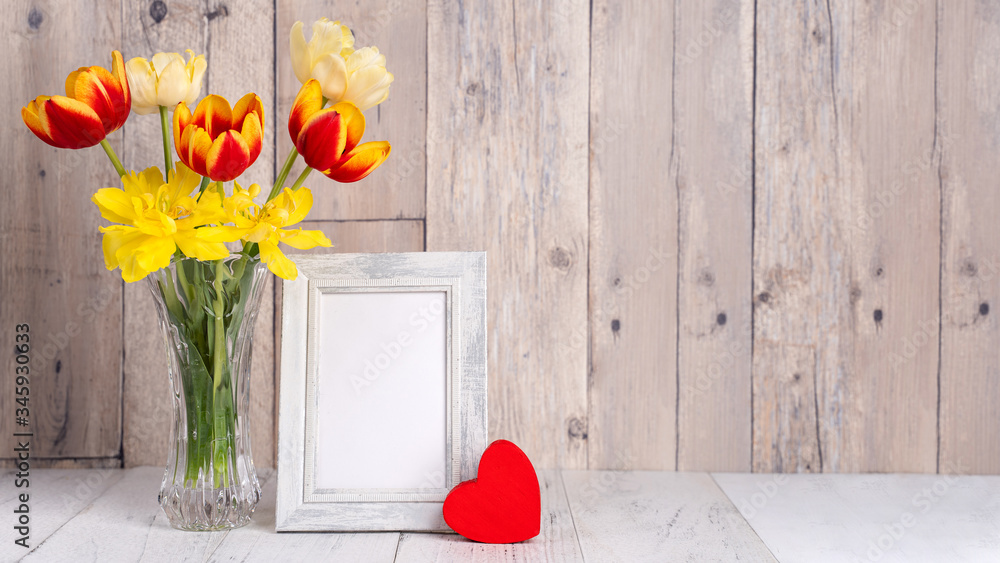 玻璃花瓶里的郁金香插花，带心形问候，木制餐桌靠背上的喷壶装饰