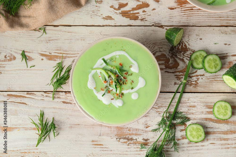 Bowl with cold cucumber soup on table