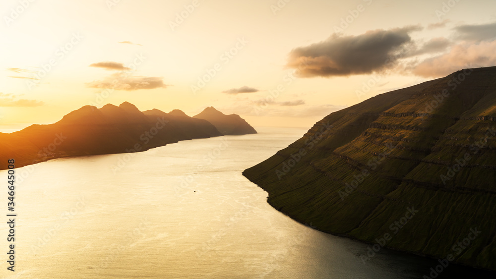 从丹麦法罗群岛卡尔索伊岛克拉克斯维克市附近的克拉库尔峰俯瞰日落美景