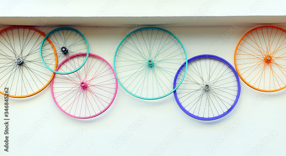 租赁和维修店墙上五颜六色的旧自行车车轮，时髦的装饰潮流概念