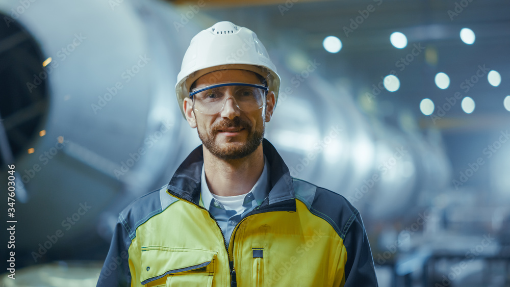 Portrait of Smiling Professional Heavy Industry Engineer / Worker Wearing Safety Uniform, Goggles an
