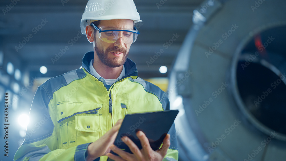Portrait of Professional Heavy Industry Engineer / Worker Wearing Safety Uniform and Hard Hat Uses T
