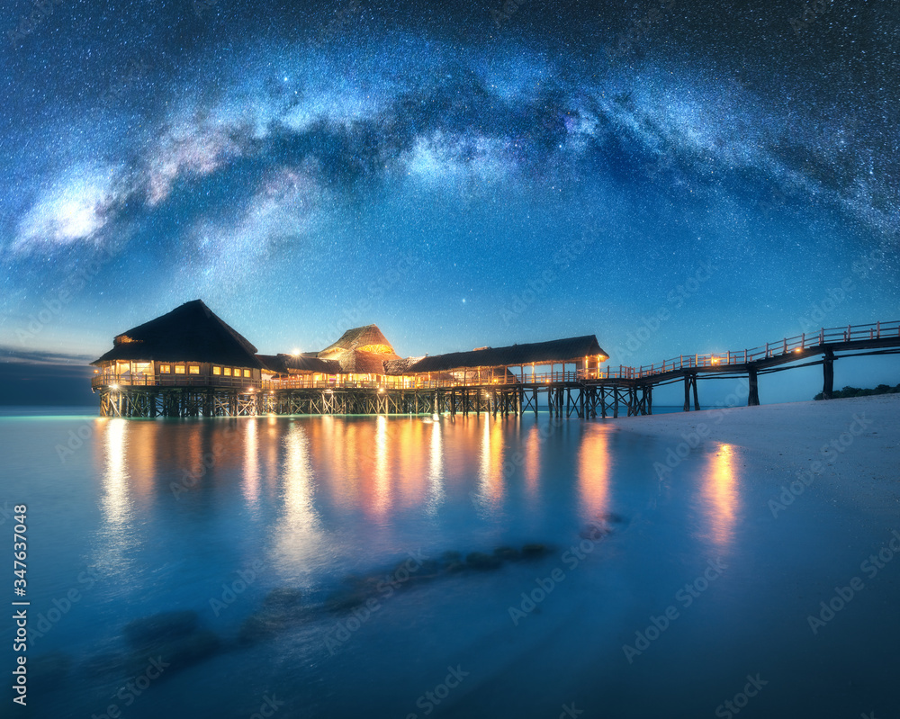 夏日星夜，水上木平房上的银河。海上酒店景观，