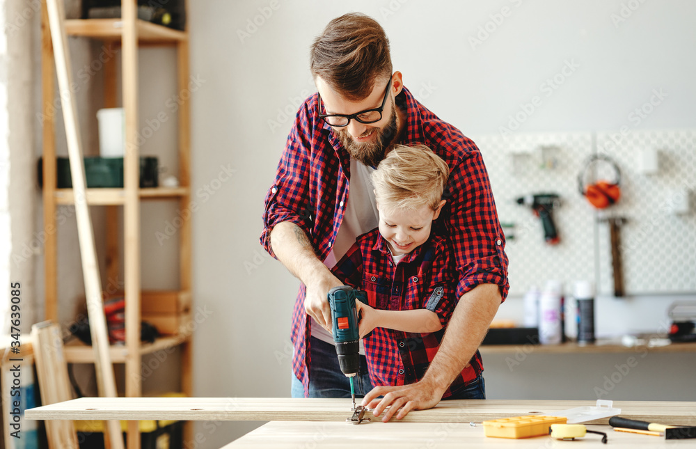 Happy father and son assembling furniture on table.