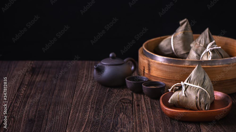 粽子-木制桌子上蒸笼里的中国粽子，黑色复古背景，代表龙