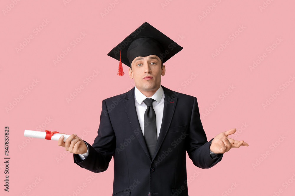 戴毕业帽，彩色背景毕业证书的年轻人