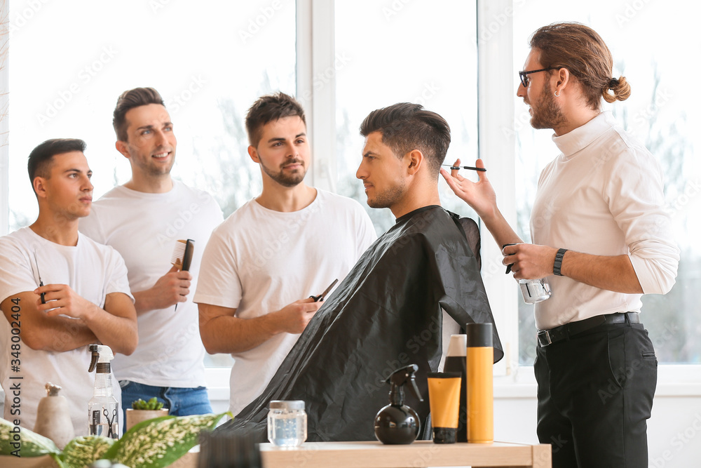 专业理发师在沙龙里教年轻男性