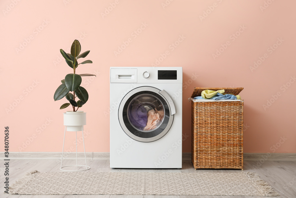 洗衣机和洗衣篮，靠近彩色墙