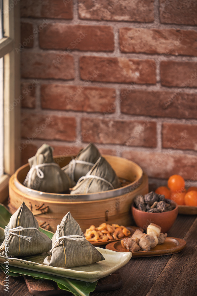 粽子——红砖木桌上的蒸笼里的中国粽子，窗户背景
