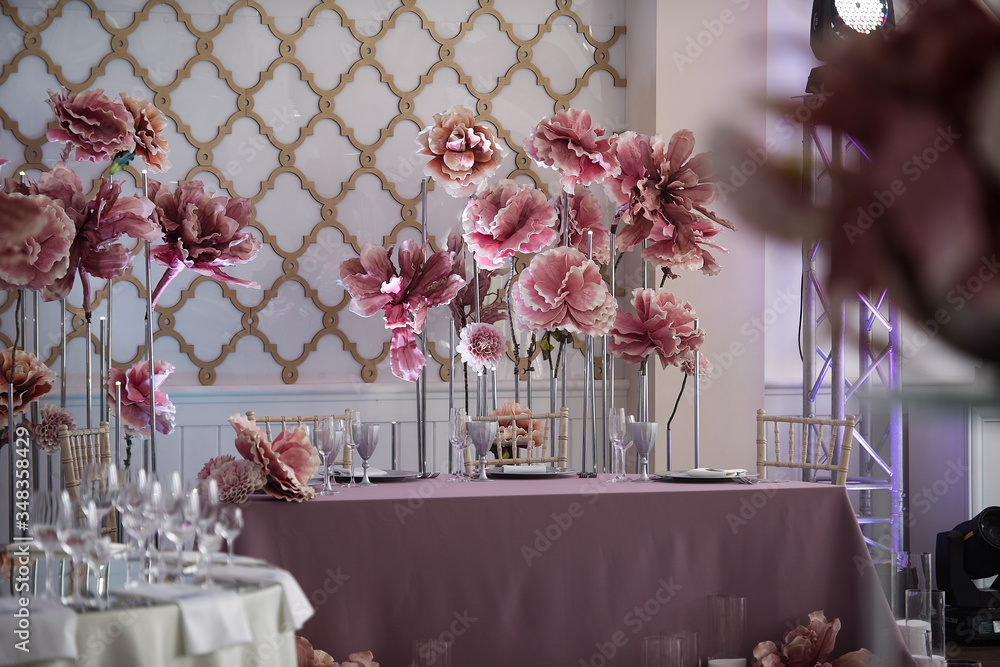 在餐厅的白色大厅里，有一些装饰有节日装饰的桌子，用于举行婚礼，d
