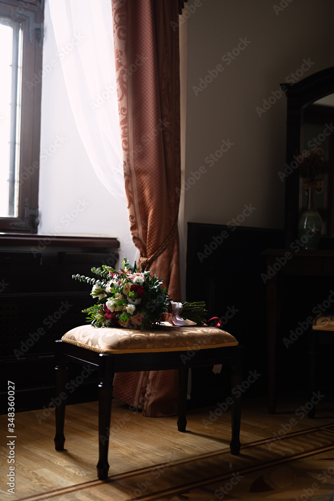 by the window there is a chair on which lies a bouquet of flowers, flowers for the bride, a wedding 