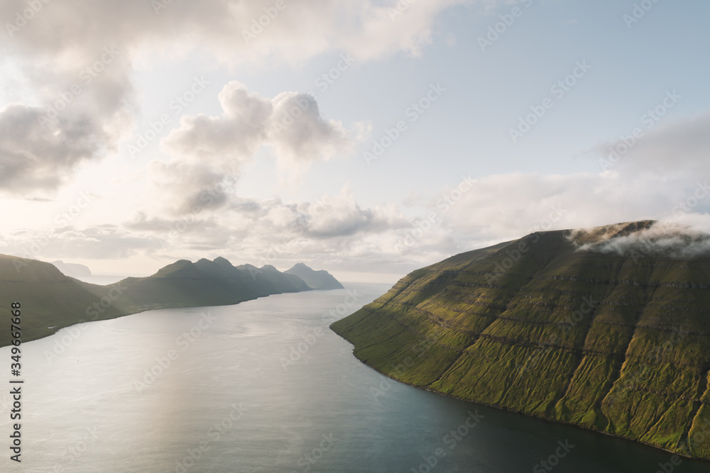 从丹麦法罗群岛卡尔索伊岛克拉克斯维克市附近的克拉库尔峰俯瞰日落美景