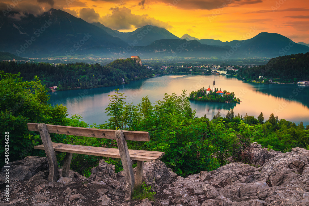 Wooden bench and stunning view with lake Bled at sunrise