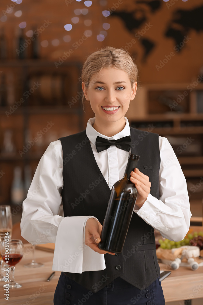 餐厅服务员拿着一瓶葡萄酒