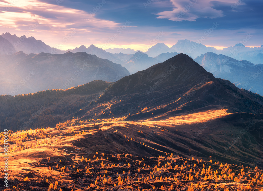 意大利多洛米蒂秋天日落时的美丽山脉。岩石、阳光和森林的景观，