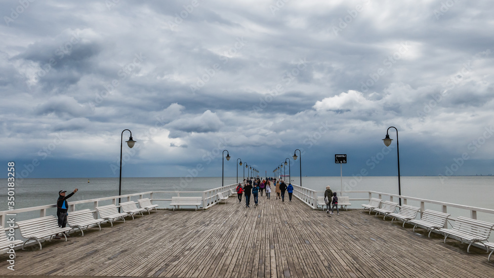 The Gdynia Orlowo Pier with tourists on a clody day.