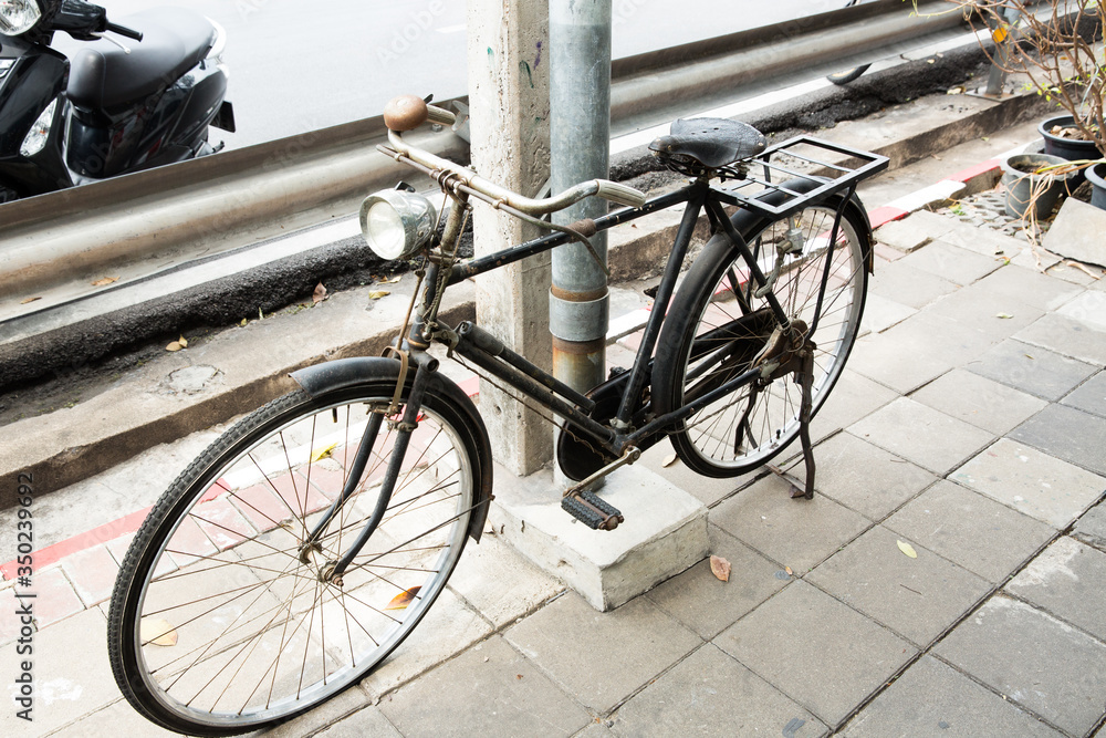 黑色古董自行车停在电线杆旁的脚浴上