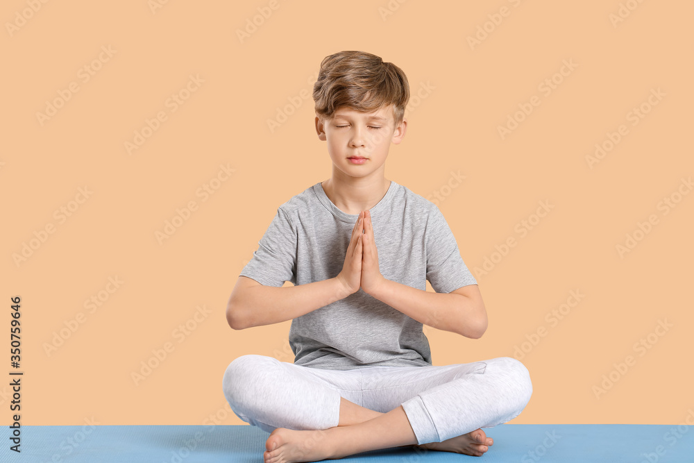 可爱的小男孩在彩色背景下练习瑜伽