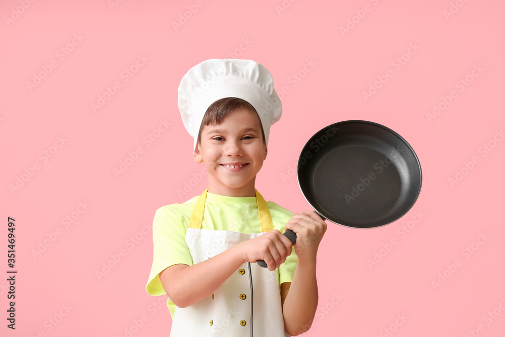 Portrait of little chef on color background