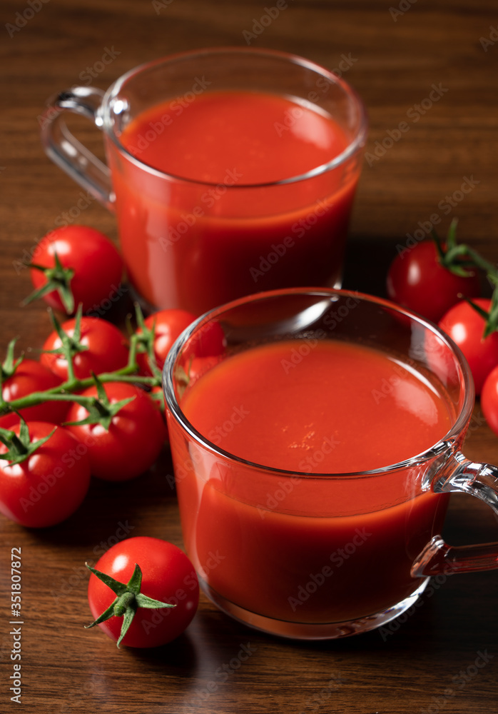 木质背景下的番茄汁和番茄