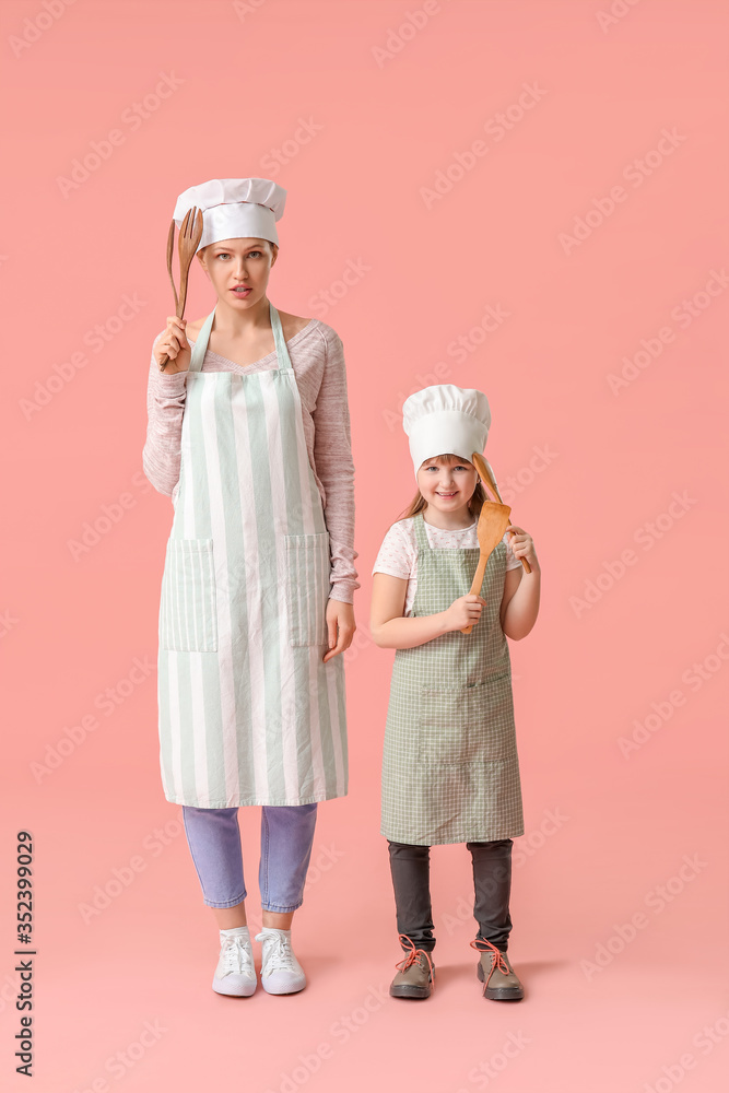 彩色背景下的女厨师和她的小女儿的肖像