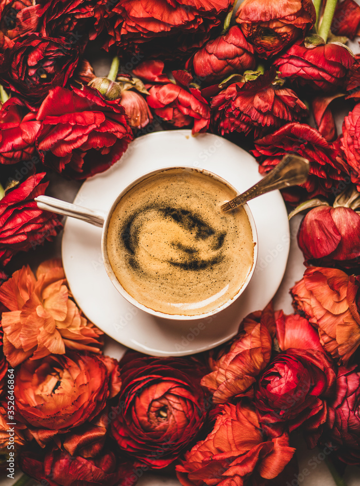 红色毛茛花背景上的白色瓷杯中的黑色浓缩咖啡，顶部vi