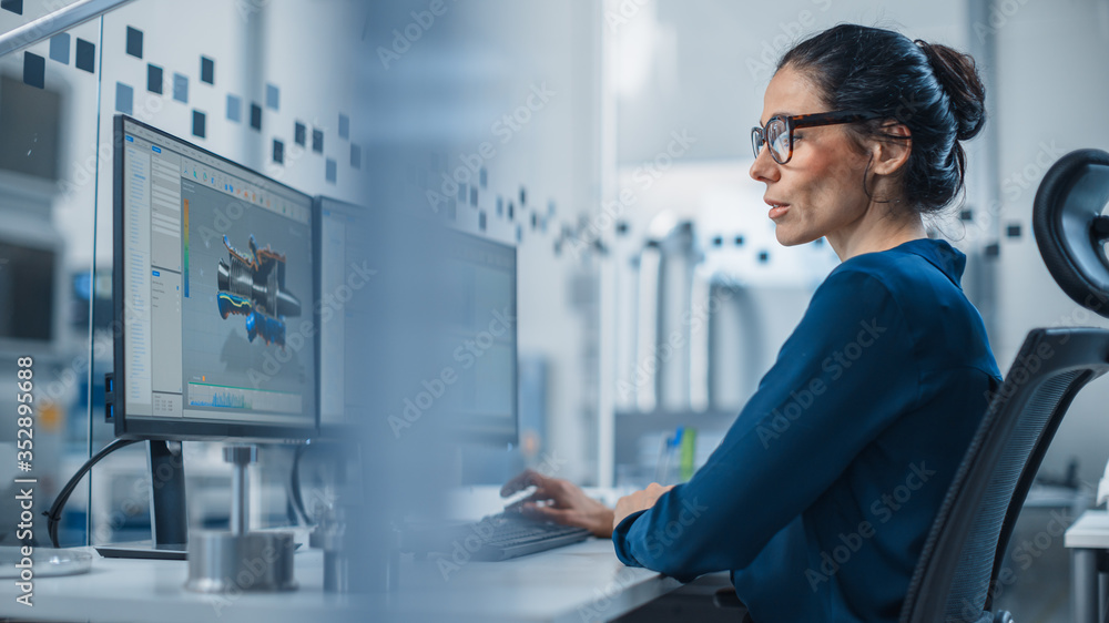 工业女工程师在个人电脑上工作，两个监视器屏幕显示CAD软件智慧
