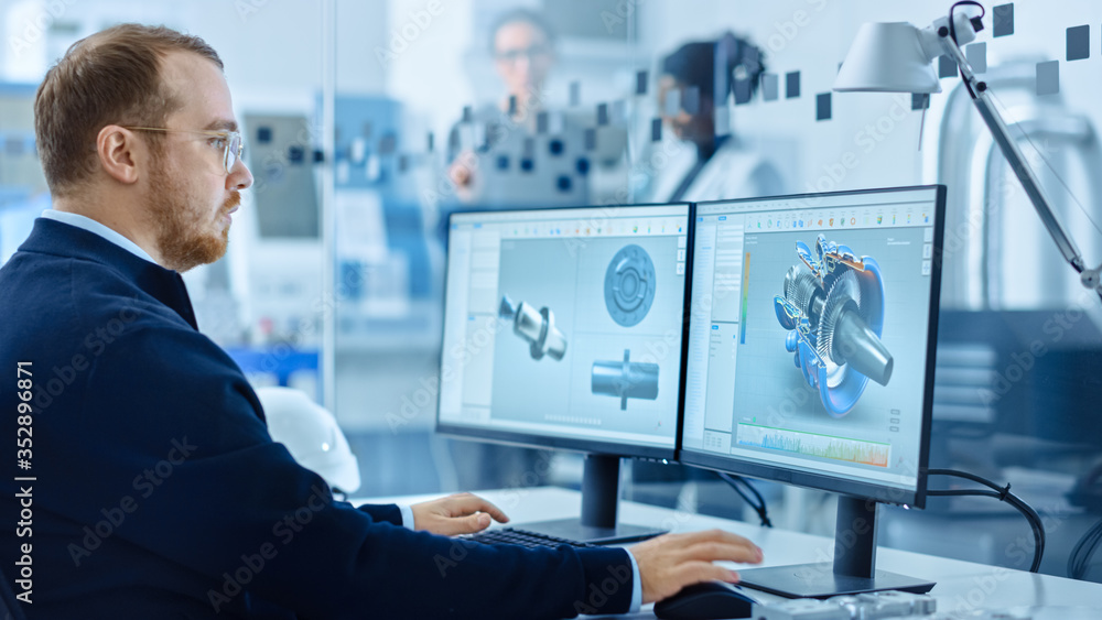 重工业工程师在个人电脑上工作，屏幕显示带有3D原型的CAD软件