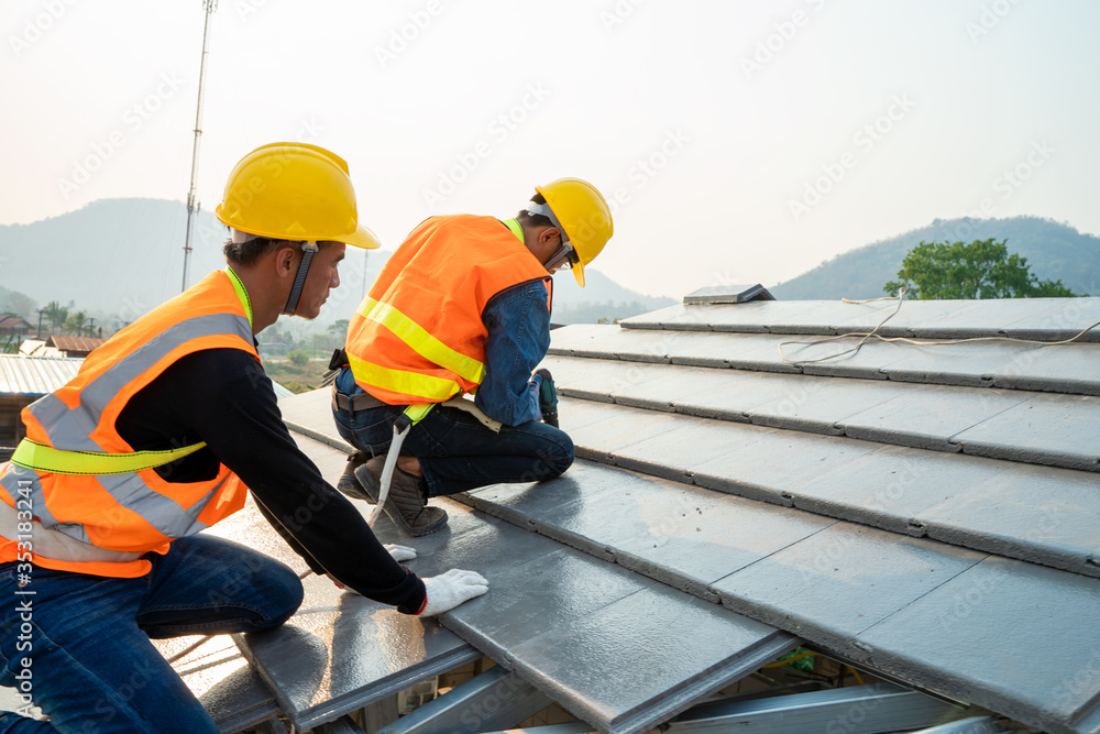 穿着特殊防护服和手套的屋顶工人在施工中安装新屋顶