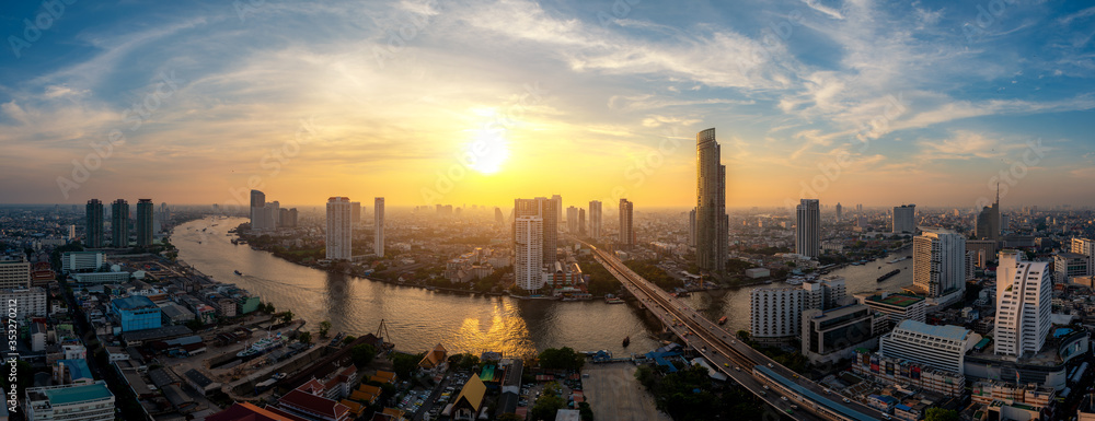 Panorama of Bangkok business district skyline and office skyscraper with Chao Phraya River during su