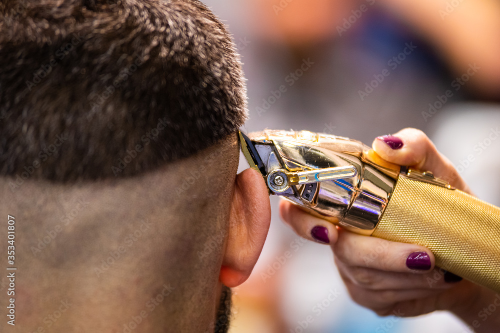 理发师用专业修剪器将客户的头发修剪到完美的形状，特写