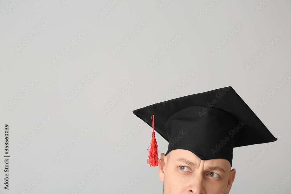 灰色背景戴毕业帽的男子